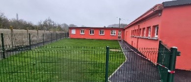 A building with a lawn and a fence AI-generated content may be incorrect.