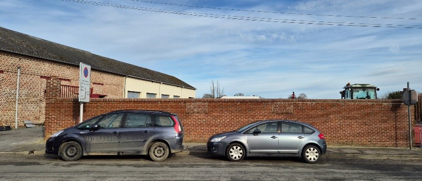 Cars parked in front of a brick wall AI-generated content may be incorrect.